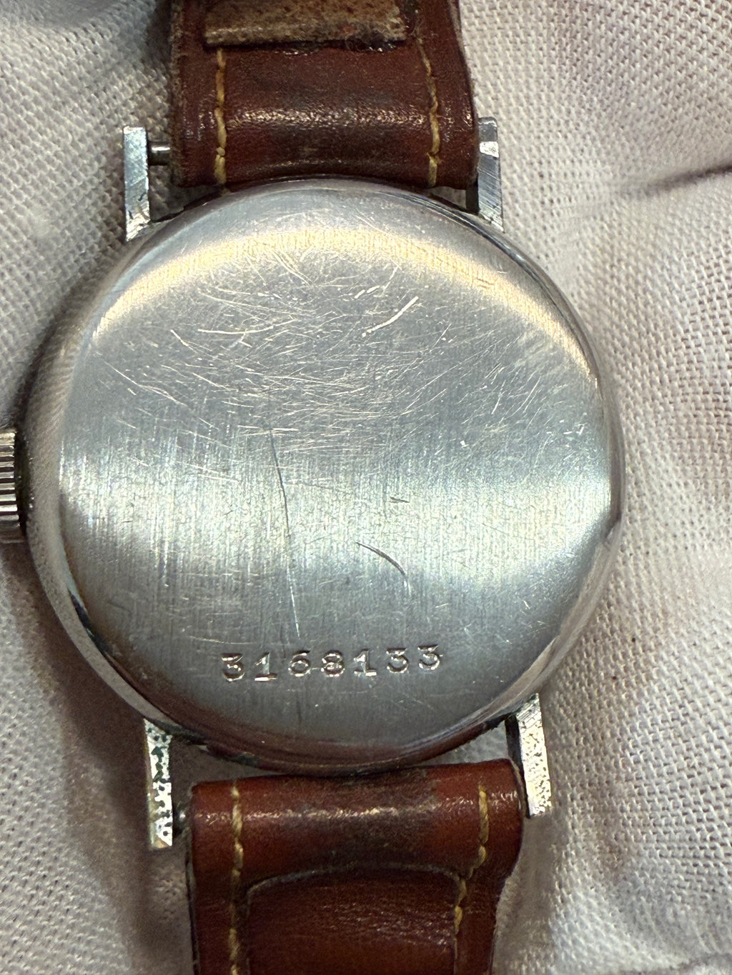 Vintage Revue Swiss wristwatch from the 1940s–1950s featuring the Revue Cal. 07 hand-wound movement, 33mm case, original dial with Roman numerals, and natural patina. Fully functional and stamped with reference number 3168133.